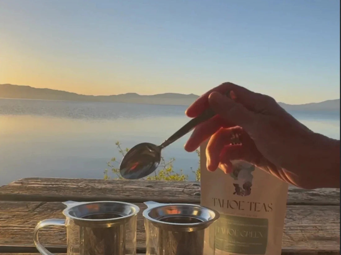 Spooning Tahoe Green tea into glass mugs over Lake Tahoe