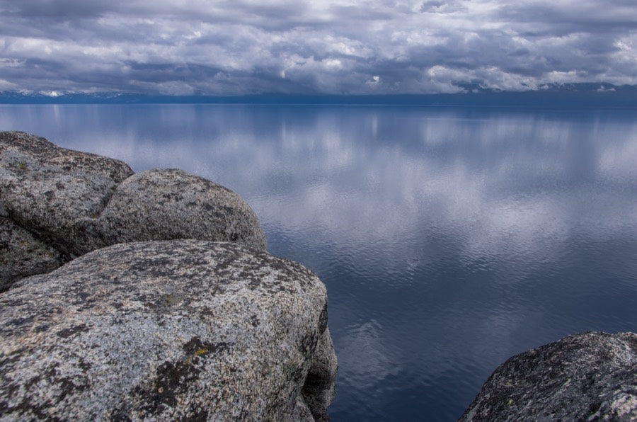 Granite boulders along the Lake Tahoe shore with the Sierra crest behind